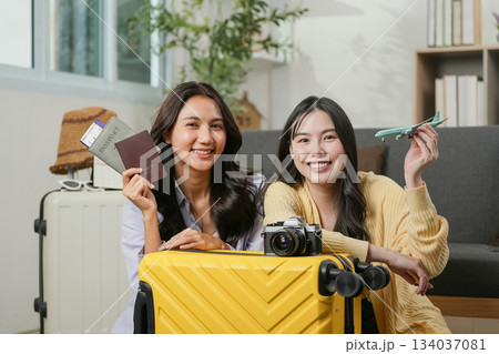 Travel Planning. Two friends excitedly preparing for their trip with passports and camera. 134037081