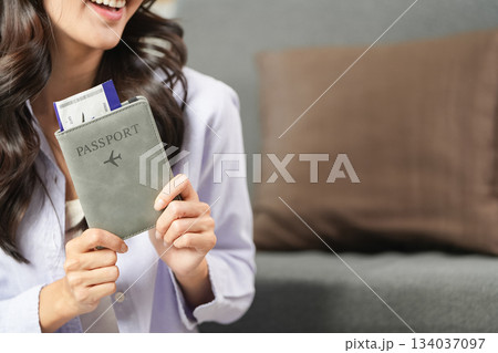 Travel Planning. Woman holding passport and boarding pass, preparing for an exciting journey. 134037097