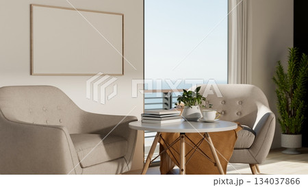 Round stool table and sofa or armchair in front of white wall with empty frame near balcony entrance Round stool table and sofa or armchair in front of white wall with empty frame near balcony entrance 134037866
