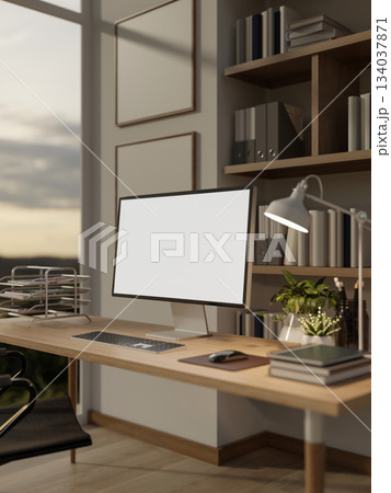 White screen computer on wooden table with books, potted plant and lamp in the study room or bedroom White screen computer on wooden table with books, potted plant and lamp in the study room or bedroom 134037871