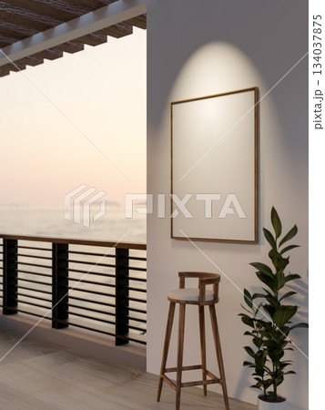 Blank wooden frame hanging on white wall over a stool chair and potted plant near river view balcony 134037875