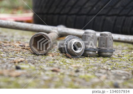 Close up of lug nuts and a wrench on a concrete surface Close up of lug nuts and a wrench on a concrete surface 134037934