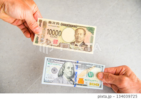 100ドル札1枚と1万円札1枚を交換するイメージアングルショット4 134039725