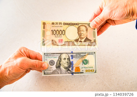 100ドル札1枚と1万円札1枚を交換するイメージアングルショット5 134039726