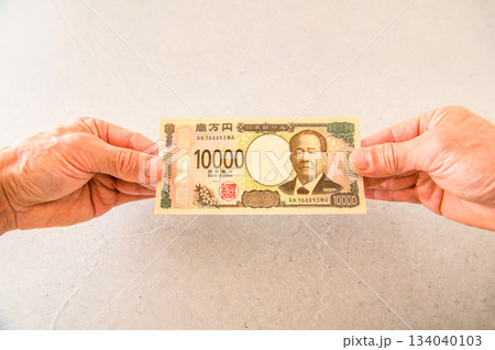100ドル札1枚と1万円札1枚を持つアングルショット 100ドル札1枚と1万円札1枚を持つアングルショット 134040103