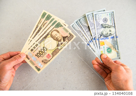100ドル札5枚と1万円札5枚を持つアングルショット 134040108
