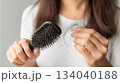 Woman holding comb show her hairbrush with loss hair problem. 134040188