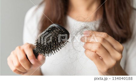 Woman holding comb show her hairbrush with loss hair problem. 134040188