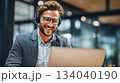 Call Center Agent with Headset Working on a Laptop in a Modern Office. 134040190