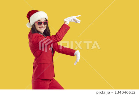 Cheerful funny woman in santa hat having fun and dancing at new year corporate event. Cheerful funny woman in santa hat having fun and dancing at new year corporate event. 134040612