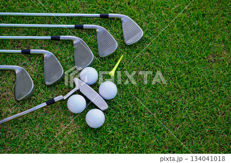 Golf equipment. Golf ball and golf club on green grass background. Golf equipment. Golf ball and golf club on green grass background. 134041018