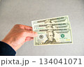 米20ドル紙幣3枚を左手で持ち左側から差し出すアングルショット 134041071