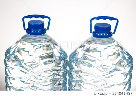 Two plastic water bottles with blue lids and a unique wavy design Two plastic water bottles with blue lids and a unique wavy design 134041457