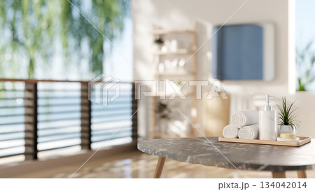 Marble stool table with towels and spa essentials in a bathroom with white wall of a sea view room. 134042014