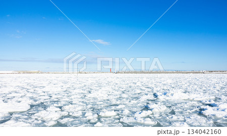 冬の青空が広がる北海道オホーツク海に打ち寄せた流氷のある風景 冬の青空が広がる北海道オホーツク海に打ち寄せた流氷のある風景 134042160