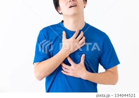 胸の痛みに苦しむTシャツ姿のミドル男性 胸の痛みに苦しむTシャツ姿のミドル男性 134044521