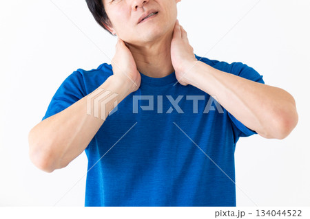 首の痛みに苦しむTシャツ姿のミドル男性 首の痛みに苦しむTシャツ姿のミドル男性 134044522