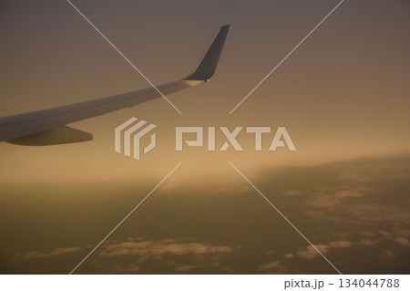 アメリカデトロイト空港離陸後の翼と夕雲 134044788