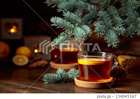 Tea with lemon and small Christmas lanterns on a wooden table. 134045167