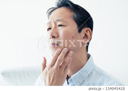 肌を気にする中高年男性 肌を気にする中高年男性 134045428