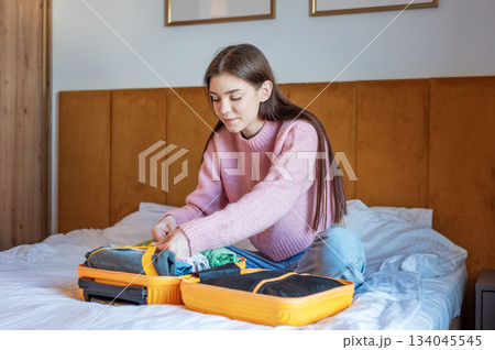 Young woman packing suitcase for upcoming travel journey 134045545