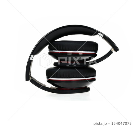 A pair of headphones with a black band and red accents 134047075