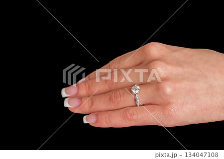 A woman's hand holding a diamond ring 134047108
