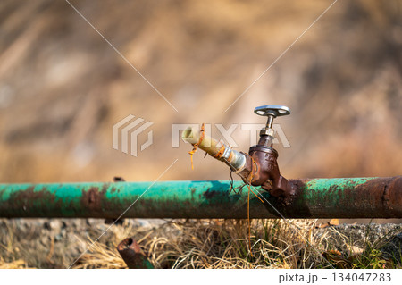 A rusty pipe with a green cap on top A rusty pipe with a green cap on top 134047283