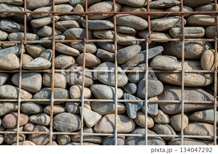 A wall made of rocks and metal bars A wall made of rocks and metal bars 134047292