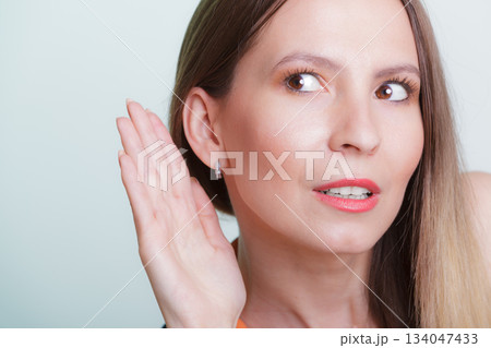 Gossip girl eavesdropping with hand to ear. Gossip girl eavesdropping with hand to ear. 134047433