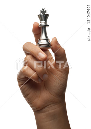 Hand holding reflective silver chess king piece against transparent background, symbolizing strategy, intellect, decisive power Hand holding reflective silver chess king piece against transparent background, symbolizing strategy, intellect, decisive power 134047493