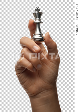 Hand holding reflective silver chess king piece against transparent background, symbolizing strategy, intellect, decisive power 134047493
