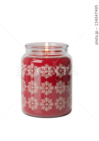 Festive red christmas candle with snowflake decorations inside glass jar, creating warm, cozy holiday atmosphere 134047495
