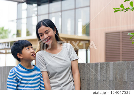 Mother child family woman parent son, people enjoying summer city street outdoors, smiling brightly, sharing joyful moment, spending quality time urban building backdrop. Mother child family woman parent son, people enjoying summer city street outdoors, smiling brightly, sharing joyful moment, spending quality time urban building backdrop. 134047525