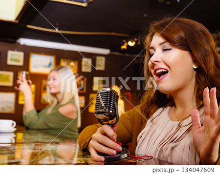 Woman singing with microphone 134047609