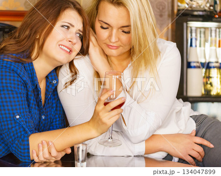 Sad woman crying and being consoled by friend. Sad woman crying and being consoled by friend. 134047899