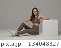 Model poses in stylish activewear against a neutral background showcasing fitness and fashion 134048327