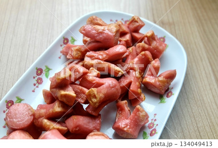 Decorative Fried Pink Sausages on White Platter 134049413