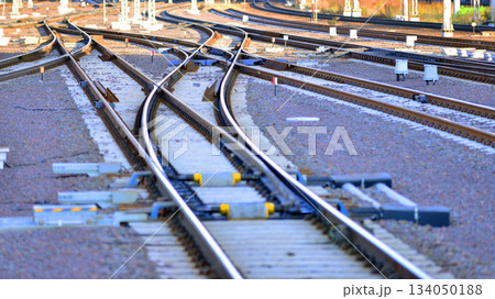 Tracks and electric high voltage for electric trains wires on reinforced concrete and metal masts against the backdrop of a city skyscrapers on a winter day. 134050188