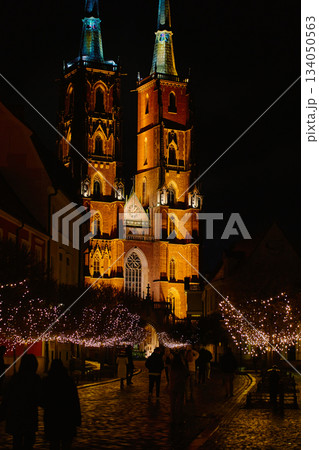 Wroclaw Cathedral at night with people walking along illuminated street Wroclaw Cathedral at night with people walking along illuminated street 134050563