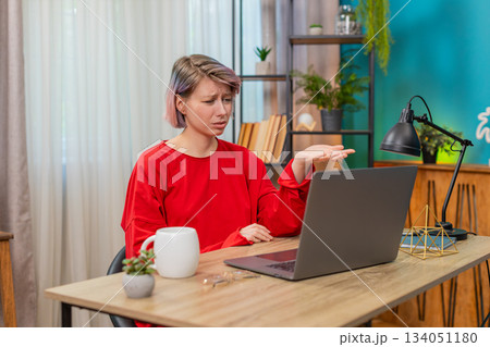 Woman emotionally arguing with laptop screen, gesturing angrily, irritated frustrated disagreement Woman emotionally arguing with laptop screen, gesturing angrily, irritated frustrated disagreement 134051180