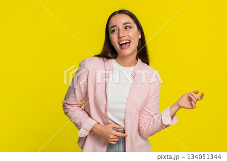 Young woman pretending to play guitar with expressive hand gestures enjoying music with passion joy Young woman pretending to play guitar with expressive hand gestures enjoying music with passion joy 134051344