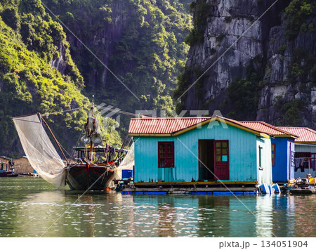 Wooden boat and colorful fishermen houses on floating rafts, Halong bay, Vietnam Wooden boat and colorful fishermen houses on floating rafts, Halong bay, Vietnam 134051904