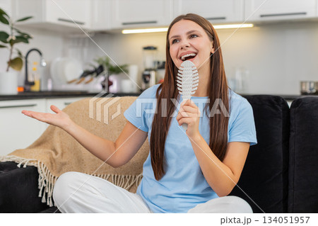 Young woman performs pop idol fantasy sings into comb as mic dances to hit song with big smile joy 134051957