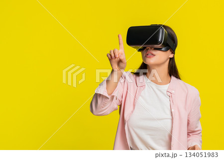 Woman wearing VR headset moving hands in air excited amazed virtual reality immersive digital world Woman wearing VR headset moving hands in air excited amazed virtual reality immersive digital world 134051983
