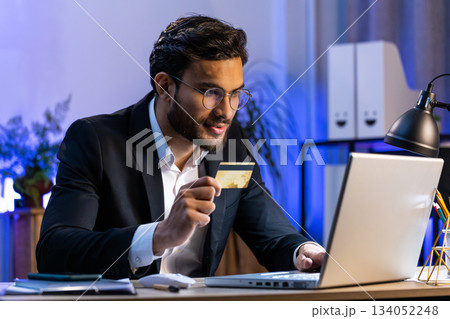 Business man making online purchase payment shopping with credit bank card and laptop at office Business man making online purchase payment shopping with credit bank card and laptop at office 134052248