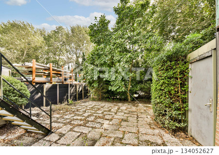A serene outdoor area featuring vibrant greenery, stone pathways, and an inviting atmosphere. Perfect for relaxation and enjoying nature. A serene outdoor area featuring vibrant greenery, stone pathways, and an inviting atmosphere. Perfect for relaxation and enjoying nature. 134052627