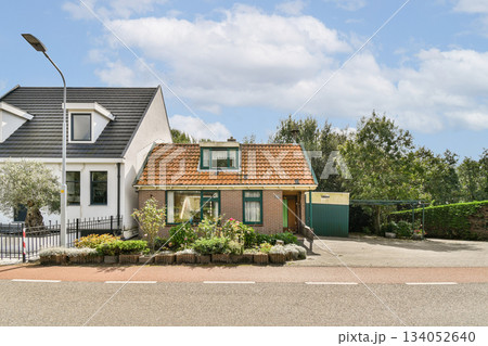 Two distinct houses showcasing unique architectural styles amidst lush greenery and well-maintained yards, perfect for family living. 134052640