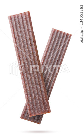 Two fruit pastille flying close-up on a white. Isolated 134053263