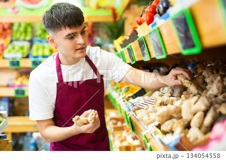 Hardworking guy seller puts ginger root for sale Hardworking guy seller puts ginger root for sale 134054558